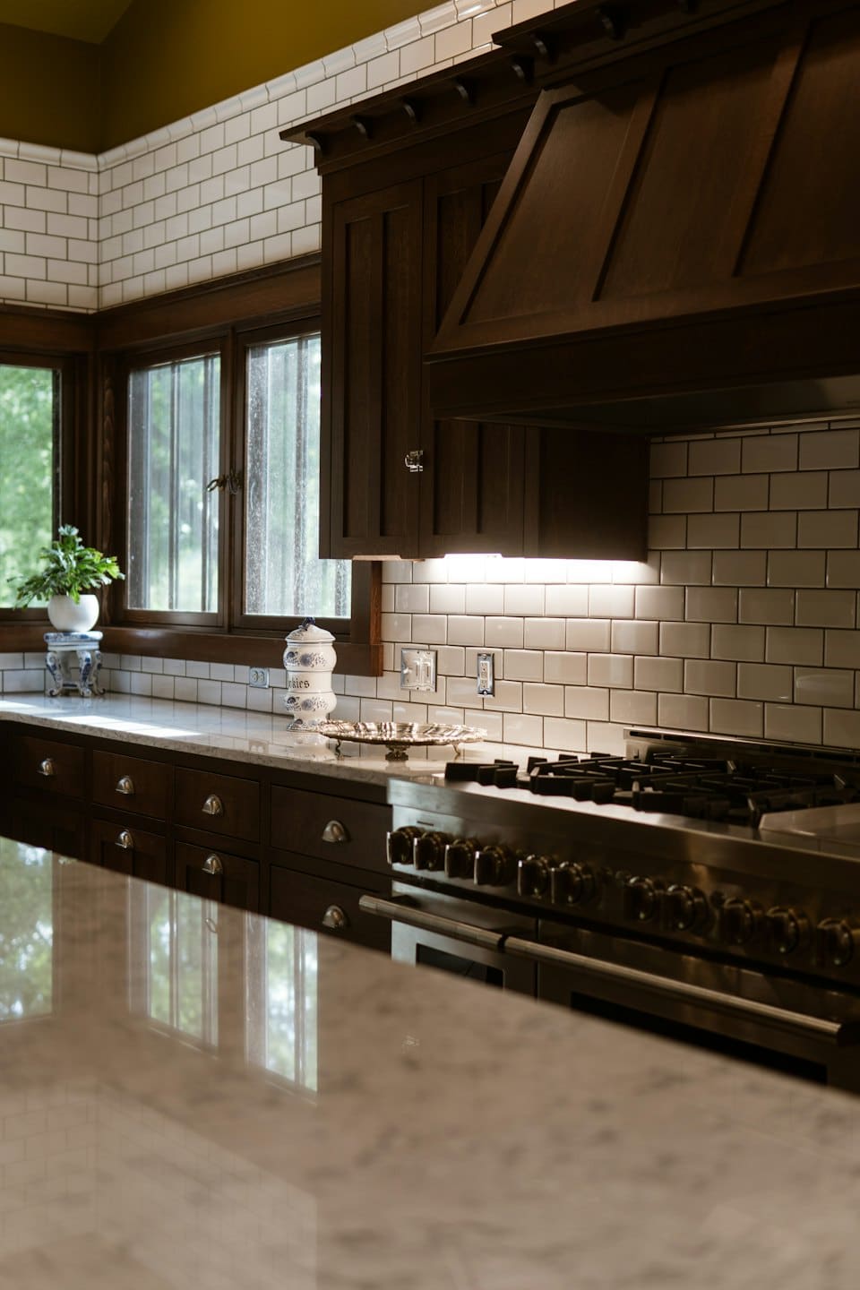 Dark wood kitchen cabinets with stainless steel appliances and marble countertops.